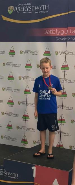 Finley Bennett poses on podium with a medal